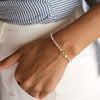 Pulseira pérolas com dois trevos em aço