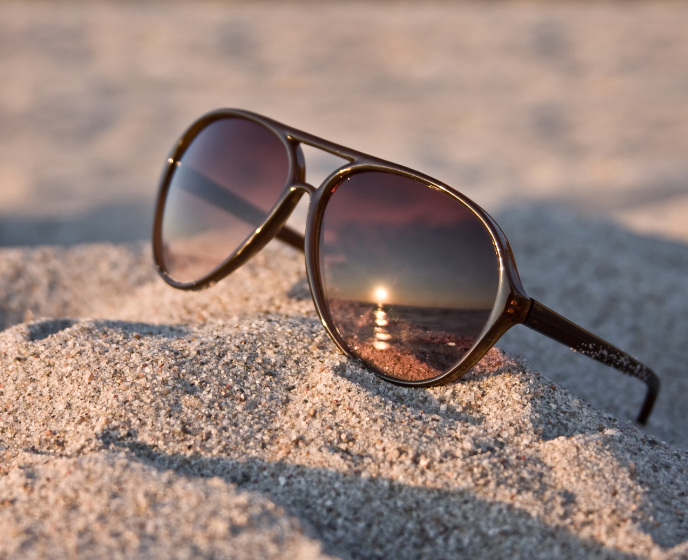Óculos de sol em contacto com areia